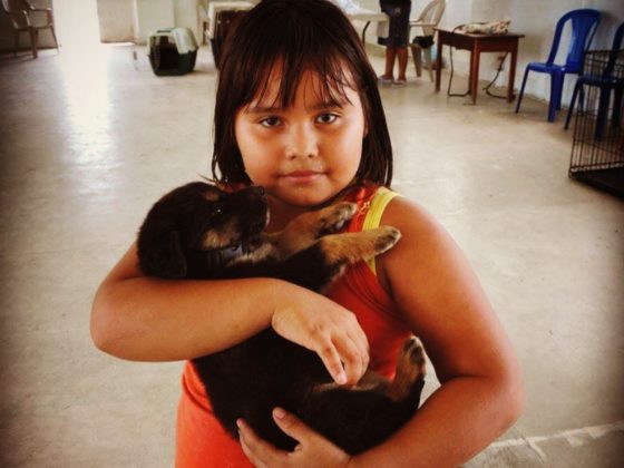 A young girl with her puppy in Belize